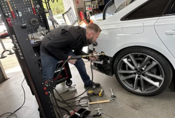 Kfz-Techniker bei der Karosserie-Instandsetzung mit Zuggerät