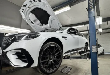 Fahrzeug mit geöffneter Motorhaube auf der Hebebühne zur Inspektion